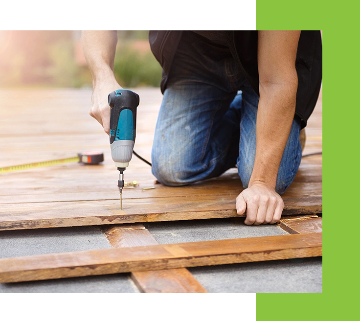 A person using a drill to install the roof of a house.